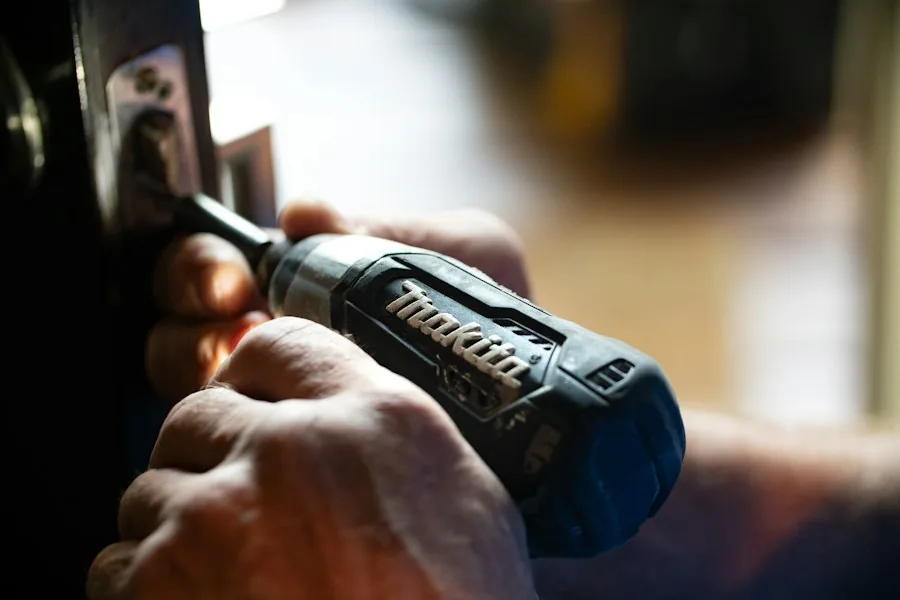Hands fixing a door latch with a cordless driver